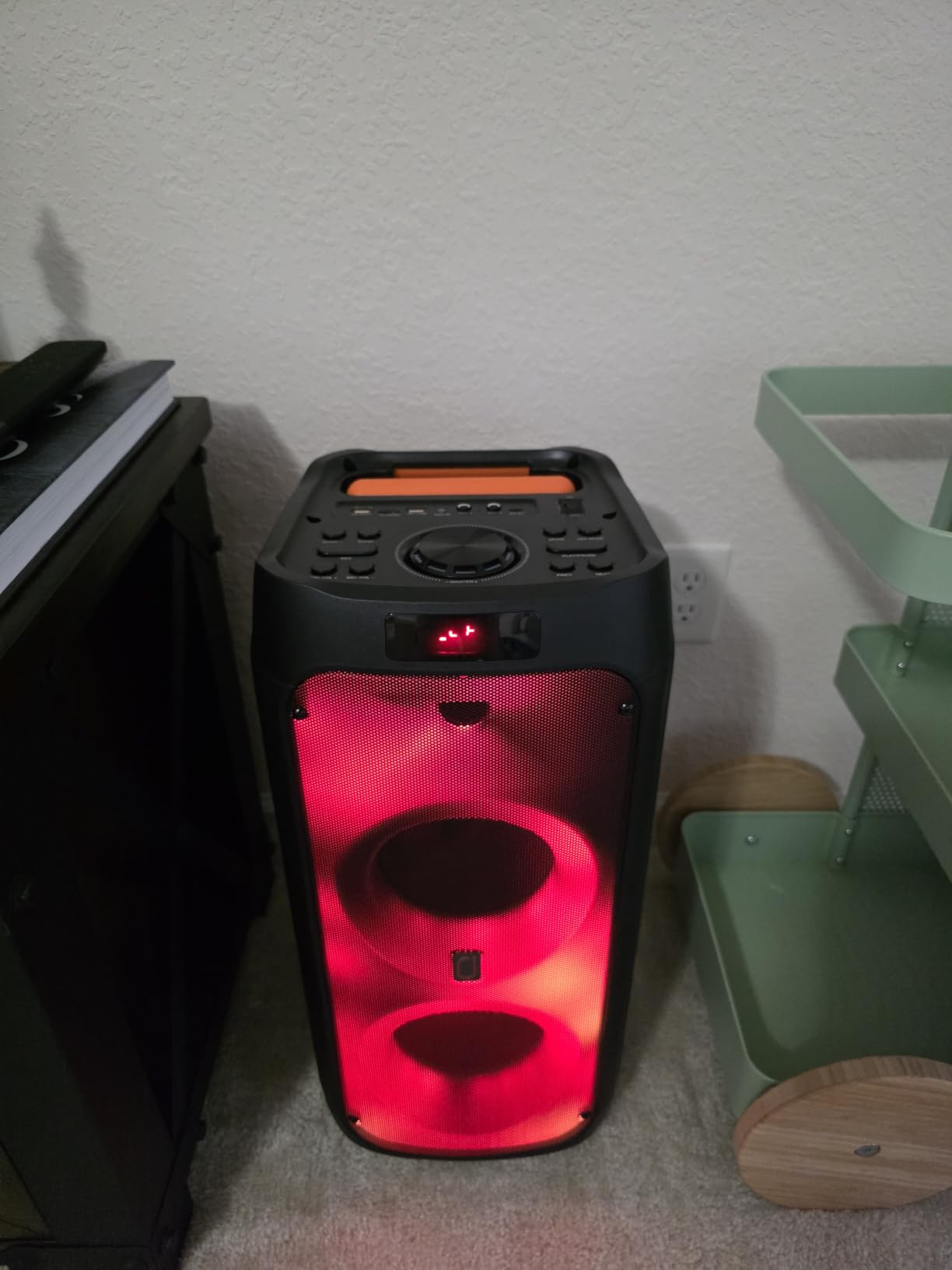 Tall HWWR karaoke machine with red lighting standing in the corner of a room